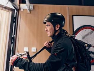 Pyöräilijä kantaa pyörää sisään