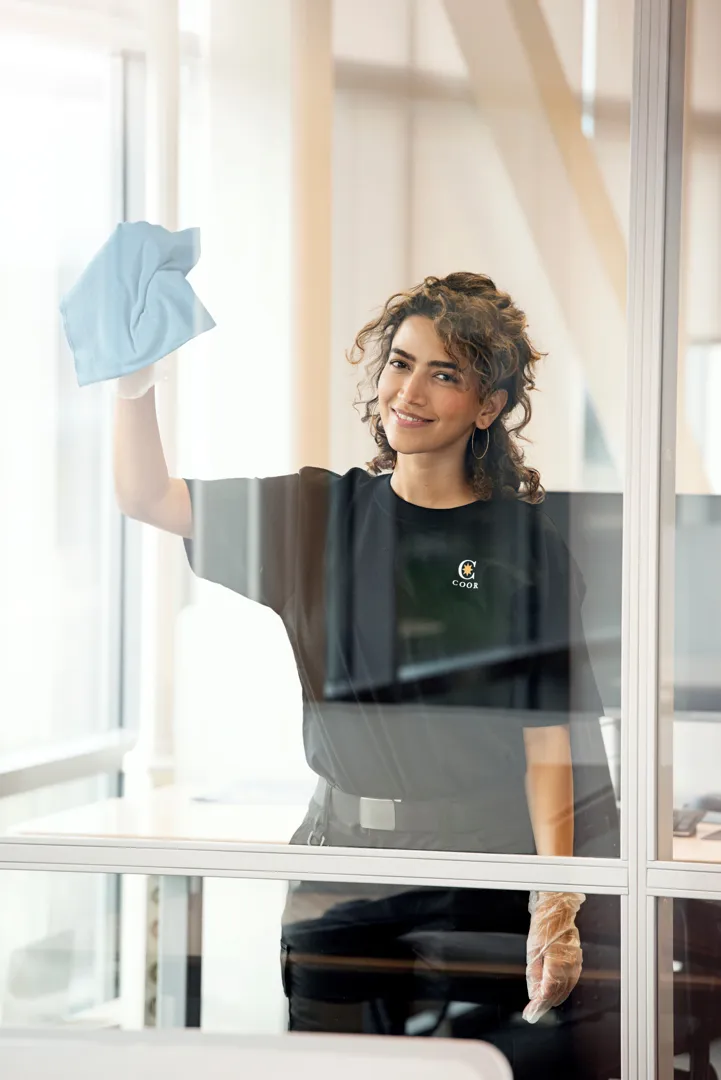 Siivooja pyyhkii ikkunaa