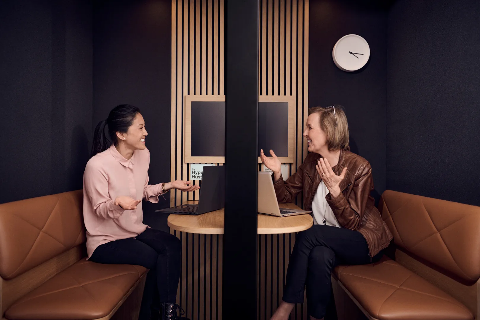 Kaksi työntekijää keskustelemassa kokoushuoneessa