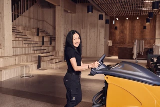 Siivooja ajaa siivouskonetta