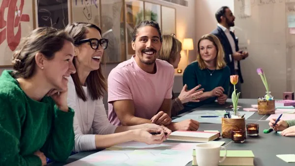 Iloisia ihmisiä pöydän ääressä