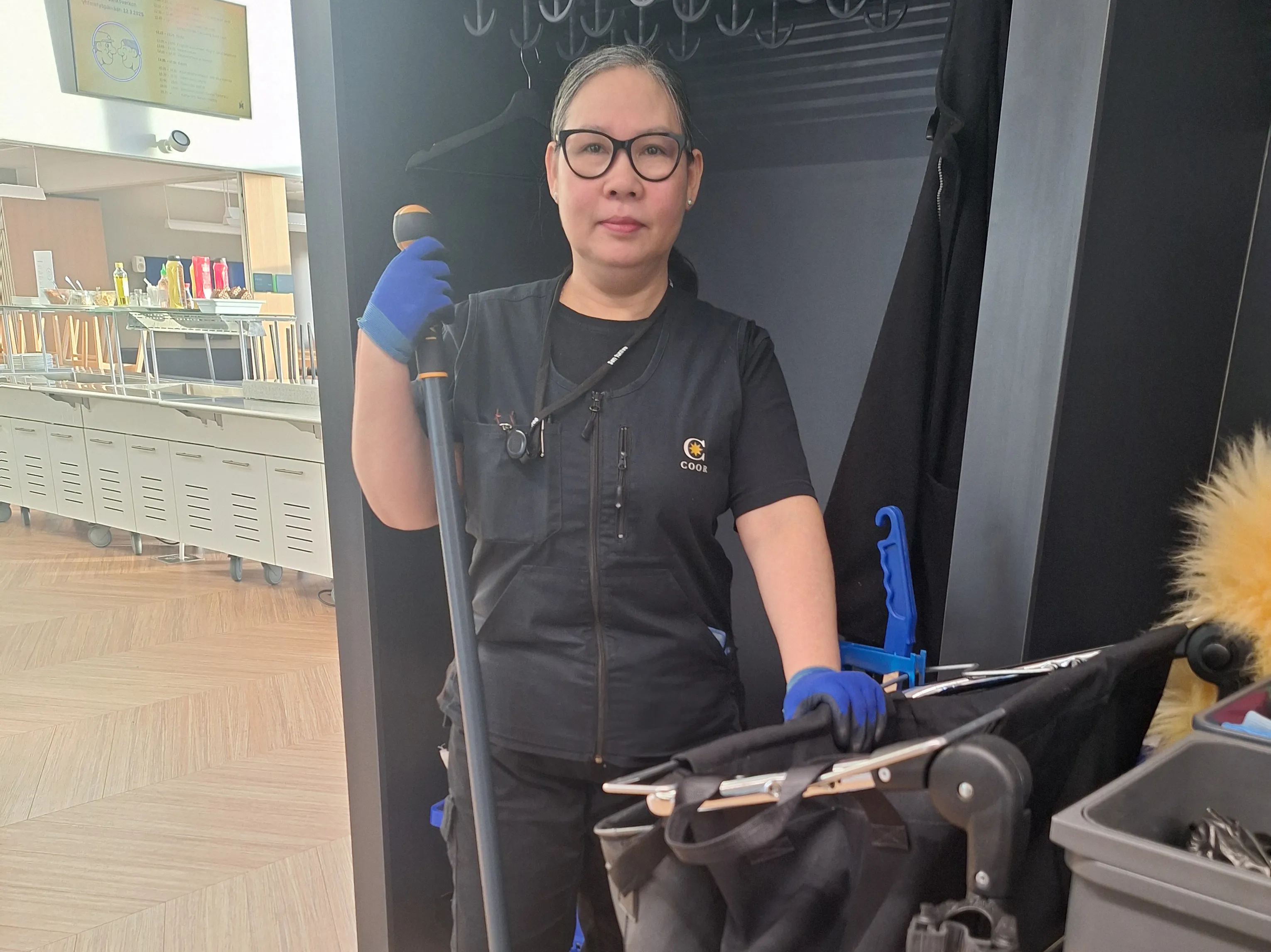 Siivooja ja siivousvaunu, jossa on kestosäkki