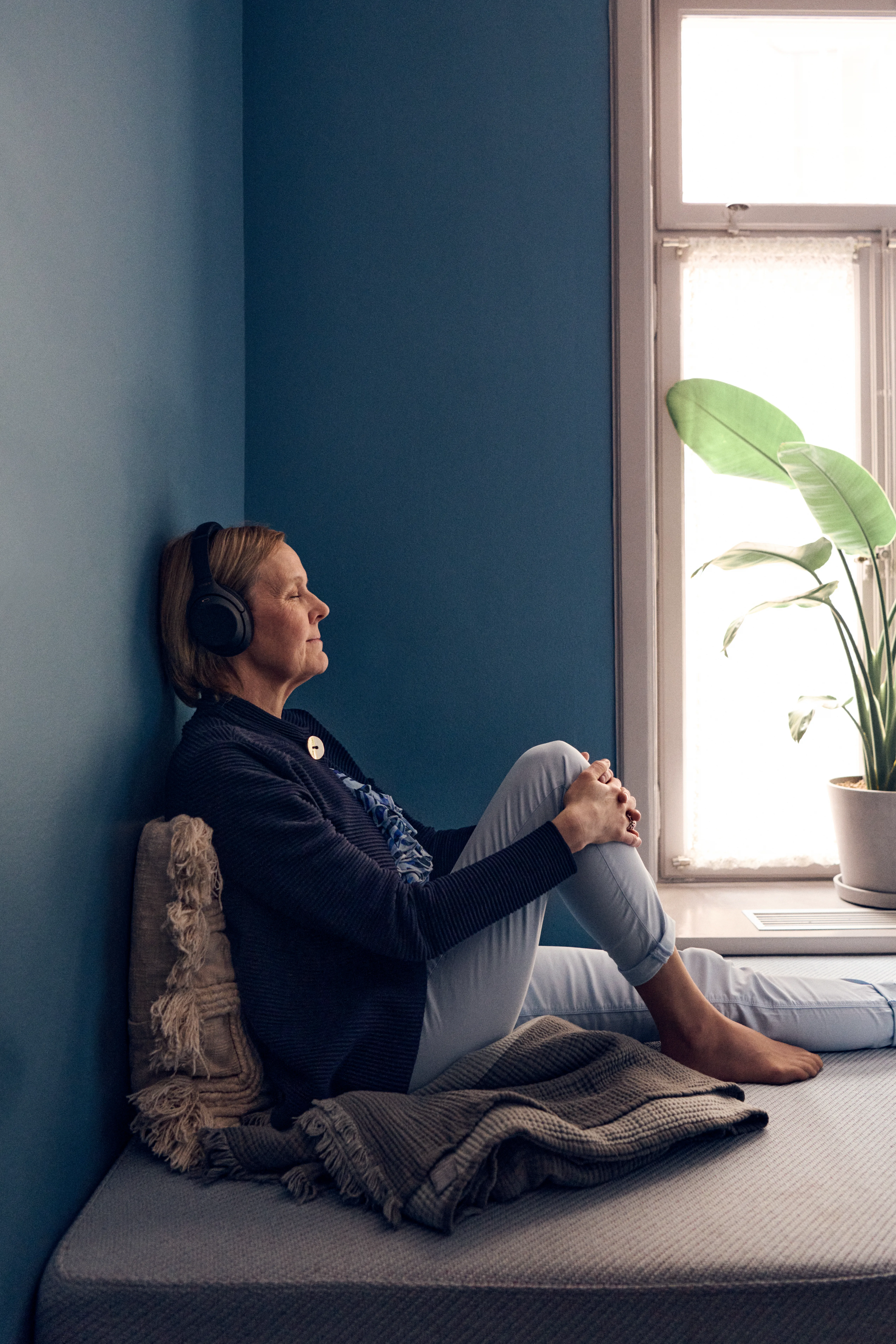 Työntekijä rentoutuu kuulokkeet päässä